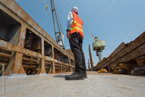 Foreman control loading Containers box from Cargo freight ship