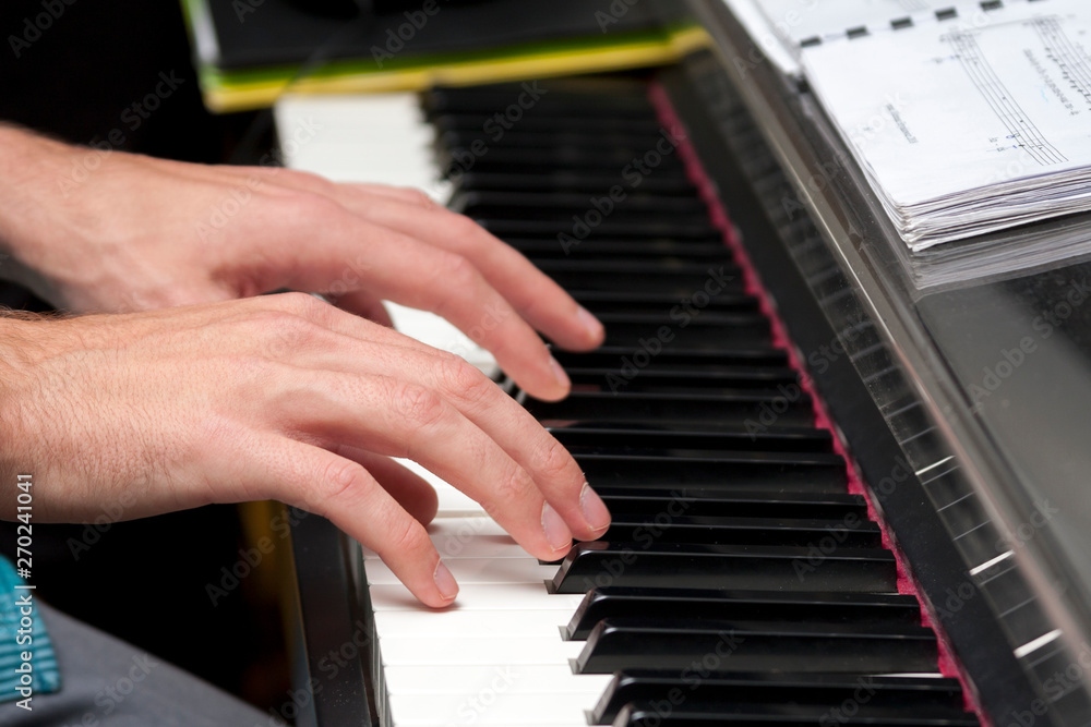 Obraz premium Hands playing on piano, keyboardHands playing on piano, keyboard, composing, home recording / studio concept