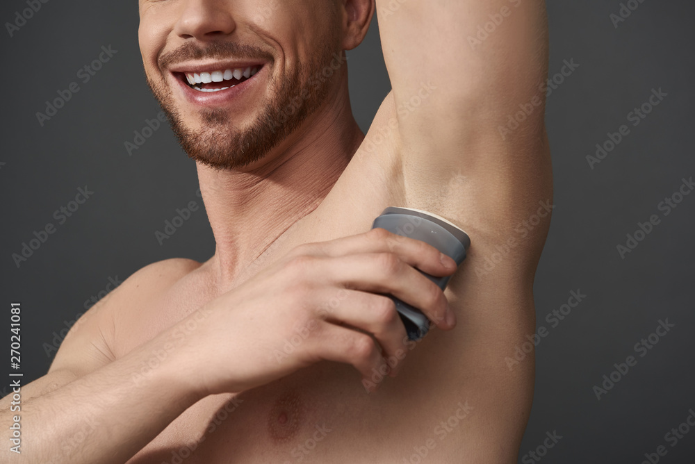 Guy takes care of his hygiene by applying deodorant to his armpit Guy takes care of his hygiene by applying deodorant to his armpit