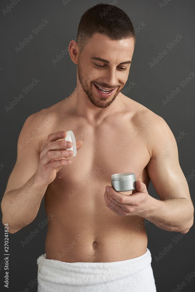 Waist up of Caucasian guy opening jar of hair gel in studio Waist up of Caucasian guy opening jar of hair gel in studio