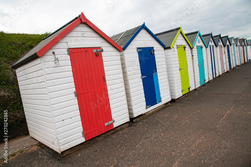Colorful beach huts with moody sky on Goodrington sands beach, Devon, England UK