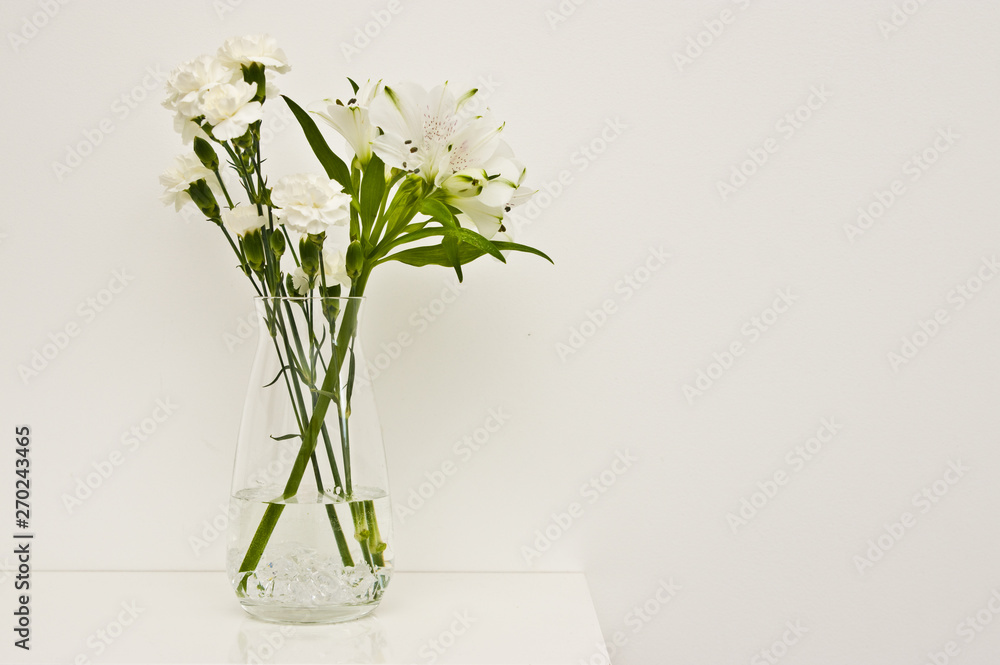White flowers in glass vase on a shelf White flowers in glass vase on a shelf