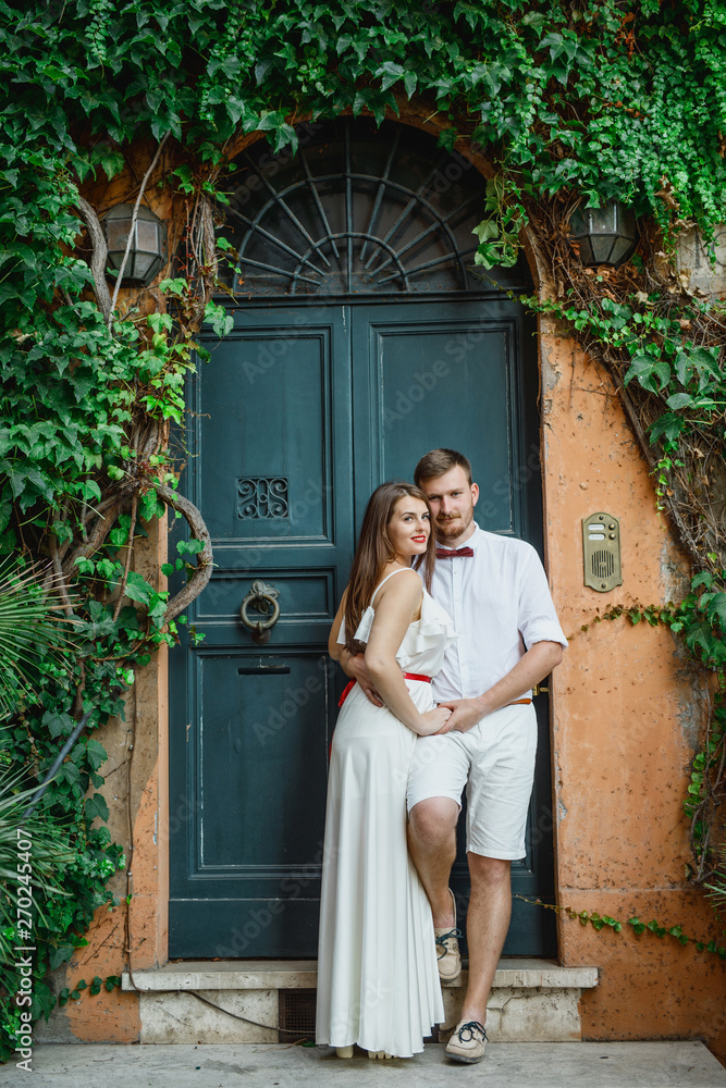 young beautiful couple in white clothes walks in Rome in Italy at sunset young beautiful couple in white clothes walks in Rome in Italy at sunset