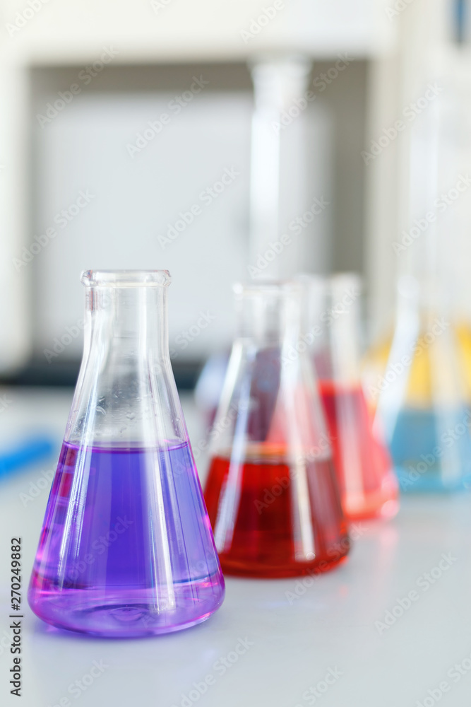 Chemical laboratory flask with blue purple-pink liquid stand on the table Chemical laboratory flask with blue purple-pink liquid stand on the table