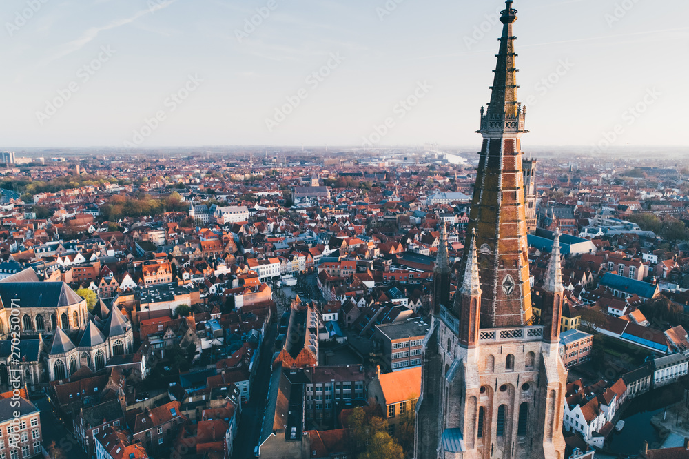 High top cityscape at sunrise. Church of Our Lady Bruges, Belgium.