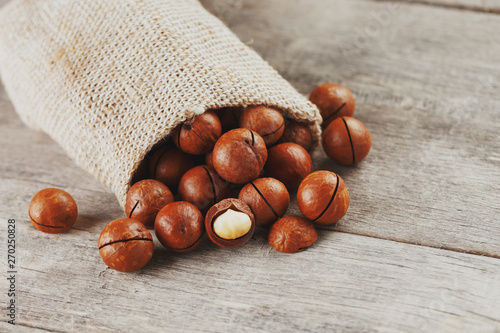 Macadamia nut on a wooden table in a bag, closeup, top view photo