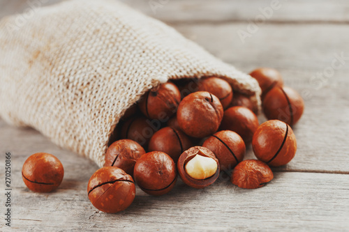 Macadamia nut on a wooden table in a bag, closeup, top view photo