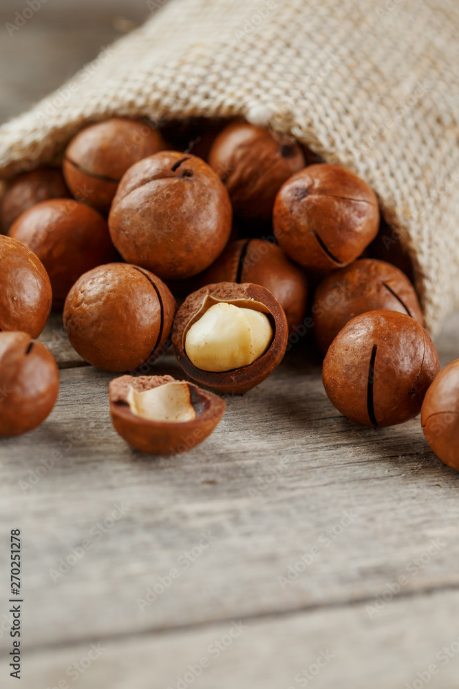 Macadamia nut on a wooden table in a bag, closeup, top view Macadamia nut on a wooden table in a bag, closeup, top view