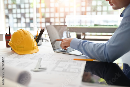 Obraz na plátně Architect man working on blueprint with engineer planing on office desk