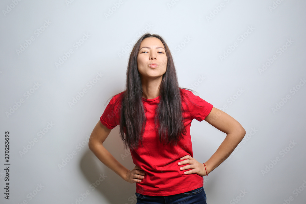 Attractive young woman posing on light background Attractive young woman posing on light background