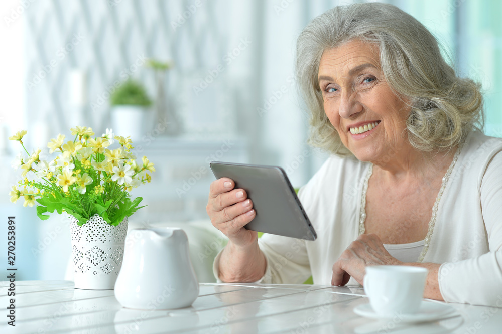 Portrait of smiling senior woman using tablet