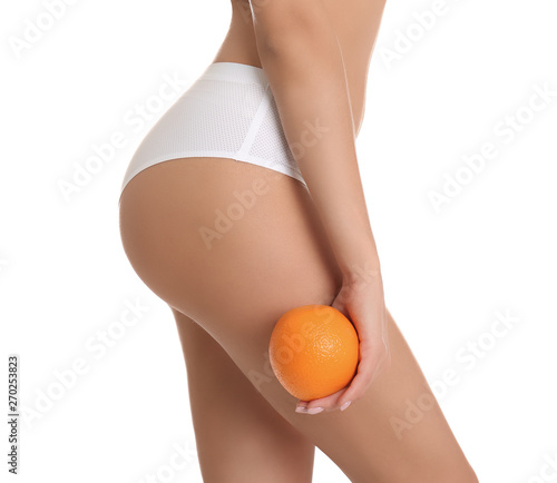 Closeup view of slim woman in underwear with orange on white background. Cell...