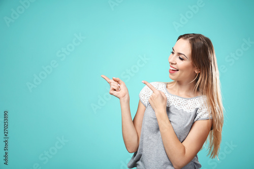 Beautiful smiling woman posing against color background