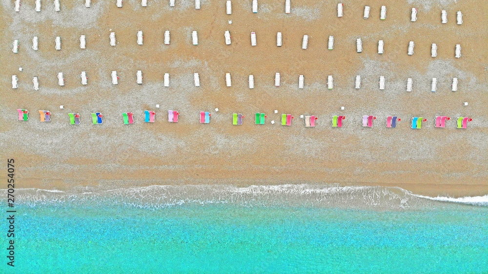 Aerial top view of sea beach coastline and deck chairs. Hotel resort and recreation concept.