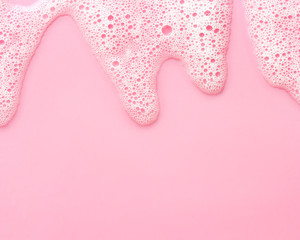 soap foam on delicate pink background with copy space