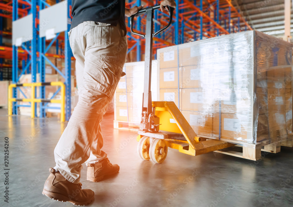 Warehouse Worker Unloading Hand Pallet jack with Packaging Boxes ...