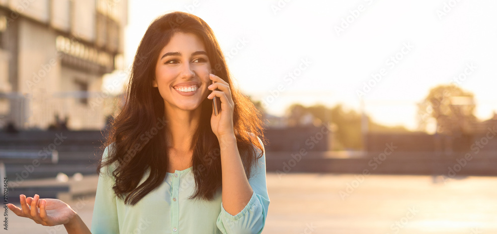 Happy woman talking on phone, walking in city