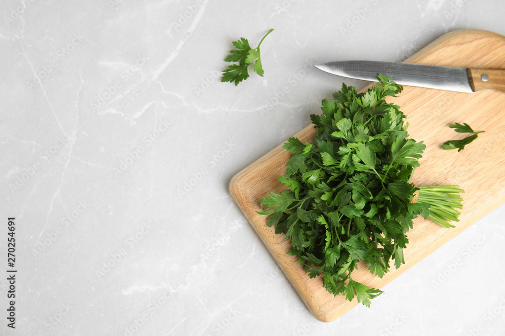 Board with fresh green parsley and knife on light background, flat lay. Space for text Board with fresh green parsley and knife on light background, flat lay. Space for text