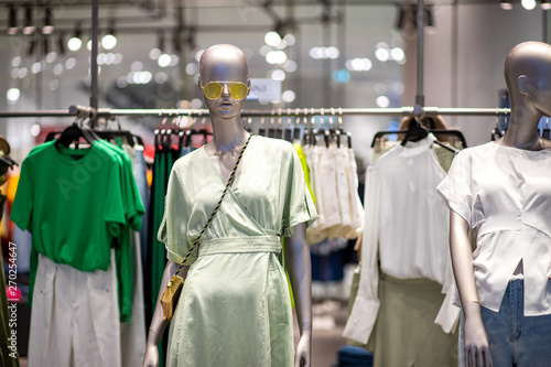 Fashion clothes putting on mannequin displaying in front the shop © AlivePhoto