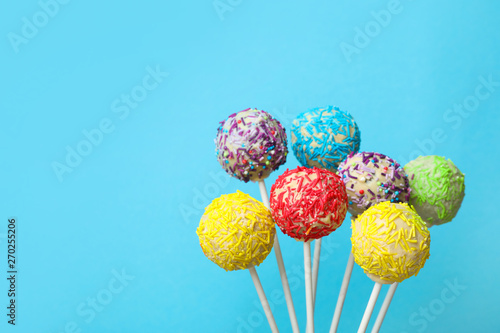 Yummy bright cake pops on color background. Space for text