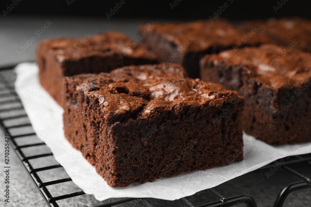 Cooling rack with fresh brownies on grey table, closeup. Delicious chocolate pie Cooling rack with fresh brownies on grey table, closeup. Delicious chocolate pie