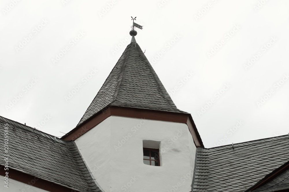 Black roof tiles of a white medieval building (Germany, Europe)