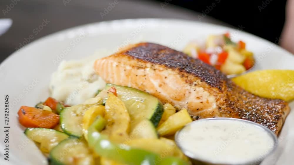 move from chicken dish to salmon dish. The camera moves from one beautiful healthy food plate to another. The first dish is a pasta, chicken & arugula plate. The camera then slowly moves to a salmon. move from chicken dish to salmon dish. The camera moves from one beautiful healthy food plate to another. The first dish is a pasta, chicken & arugula plate. The camera then slowly moves to a salmon.