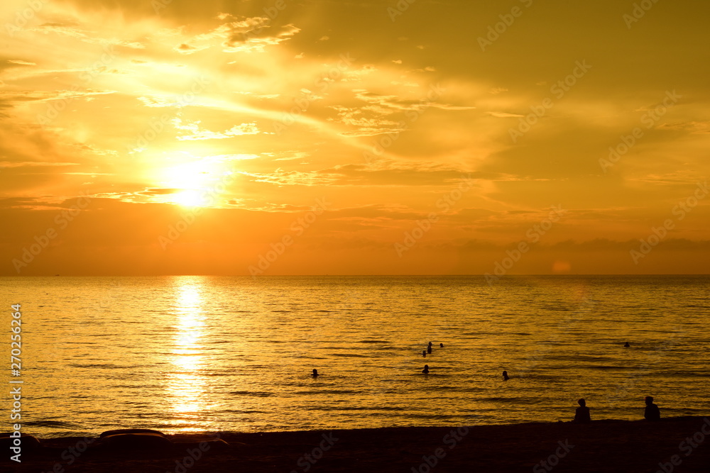 Obraz premium The rising sun and the golden yellow sky at the beach by the sea in the early morning