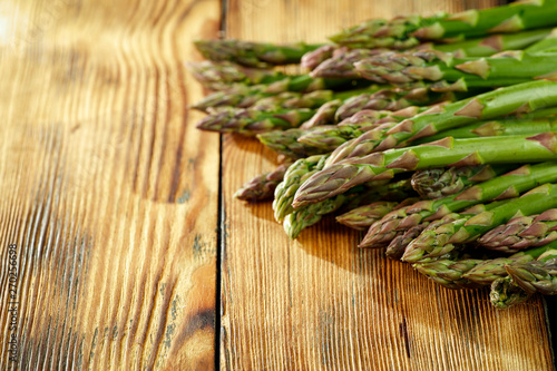Fresh green asparagus on yellow wooden table 