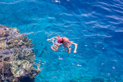 Snorkeling gear. Snorkeling girl in full face mask. Underwater swimming in Red sea near a coral reef. Tropical vacation activity snorkeling