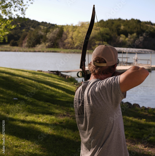 Male archer aims bow