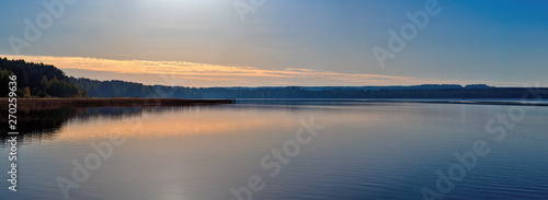 Panorama of a magnificent sunset on the lake  with a Golden-blue color