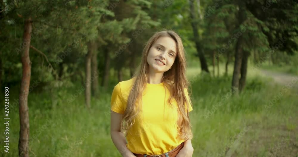 Beautiful girl smiling and looking at the camera in the forest Beautiful girl smiling and looking at the camera in the forest