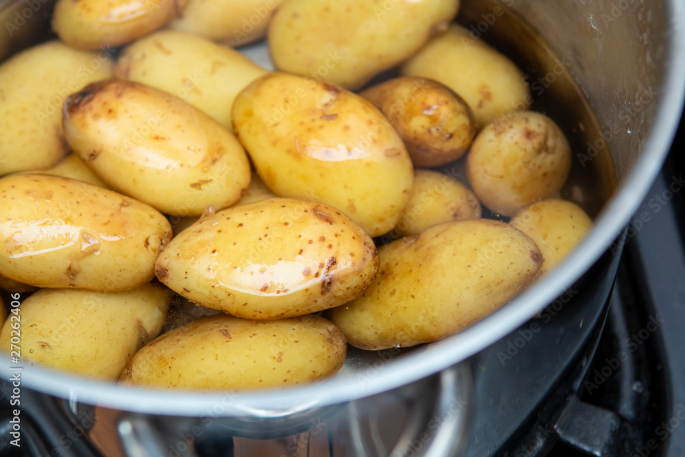 jersey royal potatoes in a saucepan full of water jersey royal potatoes in a saucepan full of water
