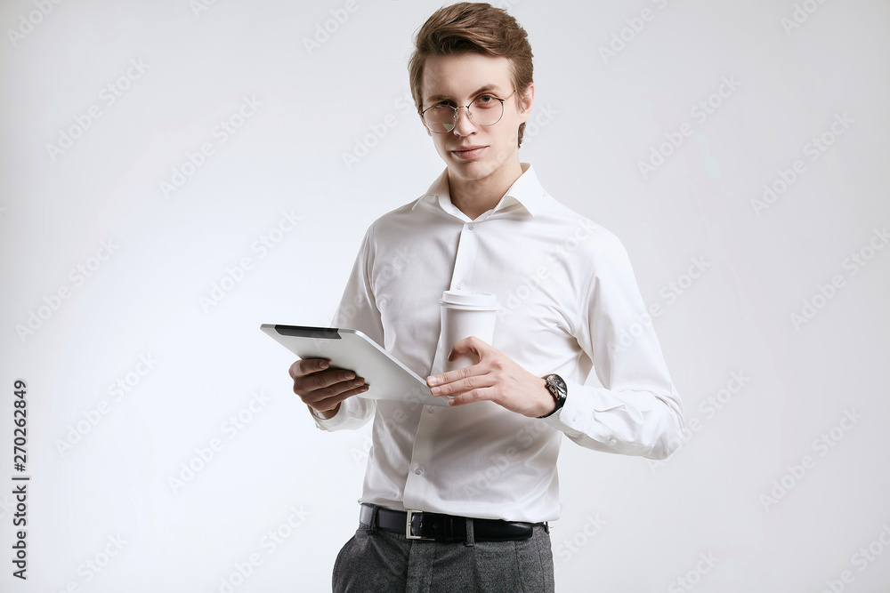 Confident young businessman in shirt with cup of coffee and tablet Confident young businessman in shirt with cup of coffee and tablet