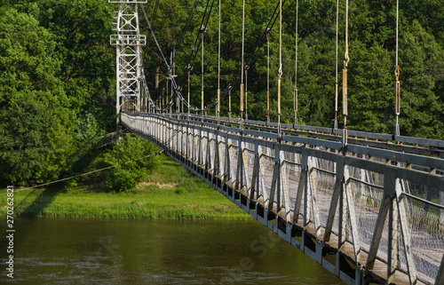 Side view on the suspension pedestrian bridge through the Neman River in the city Mosty, Republic of Belarus
