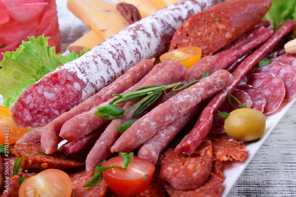 Smoked sausages assortment on the white tray. Meat plate Smoked sausages assortment on the white tray. Meat plate