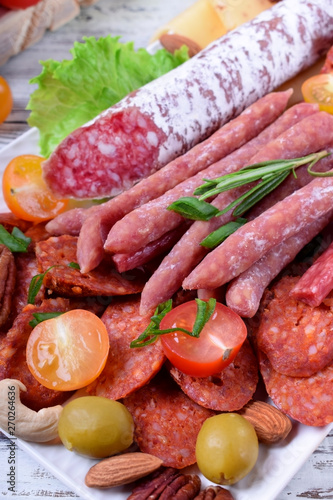 Smoked sausages assortment on the white tray. Meat plate