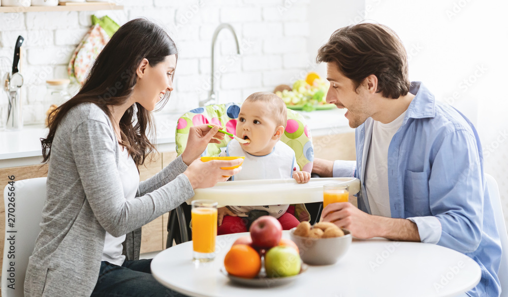 Good looking young family eating breakfast together with their baby Good looking young family eating breakfast together with their baby
