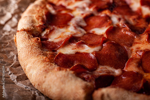 pizza peperoni on black stone background