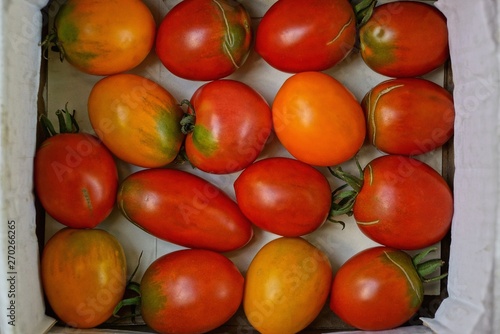 natural texture of red and yellow tomatoes in a white box