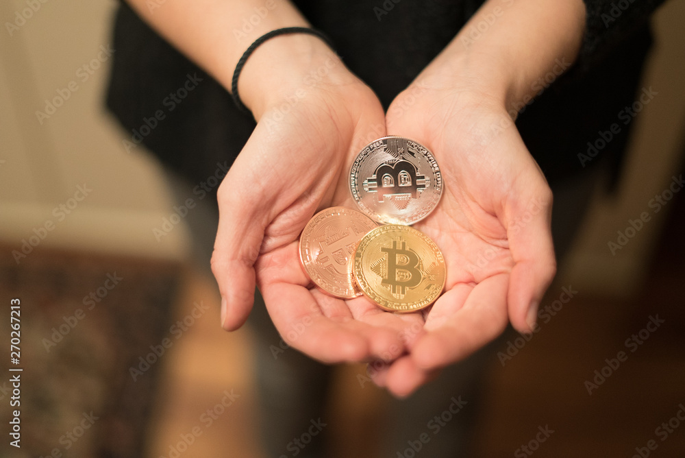 Cryptocurrency golden bitcoin coin. Man holding in hand symbol of crypto currency - electronic virtual money for web banking and international network payment, selective focus, toned Cryptocurrency golden bitcoin coin. Man holding in hand symbol of crypto currency - electronic virtual money for web banking and international network payment, selective focus, toned