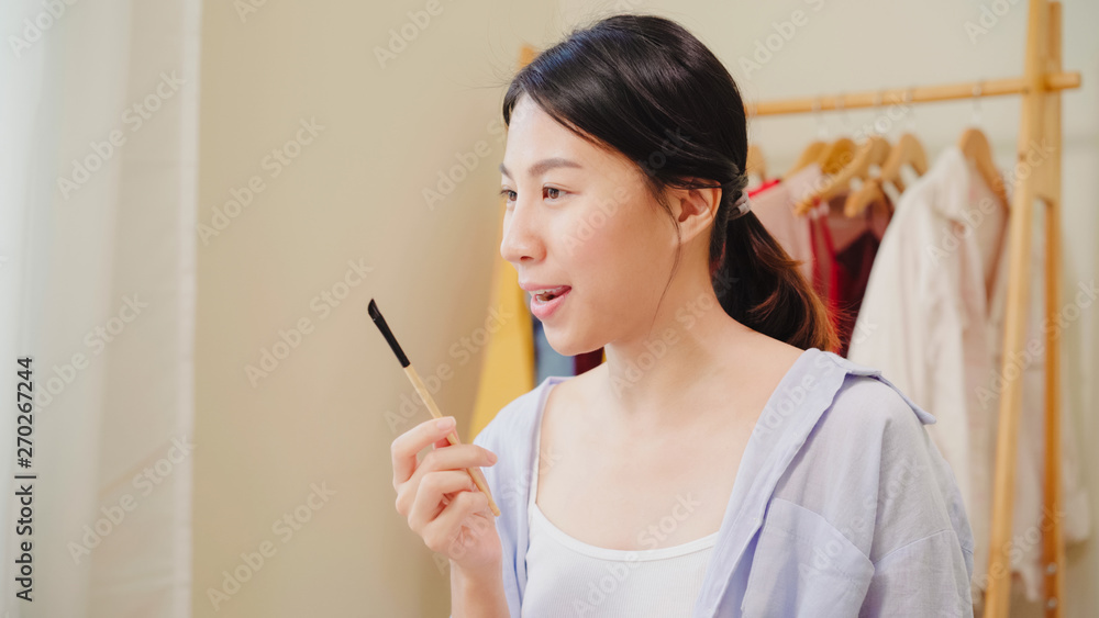 Beauty blogger present beauty cosmetics sitting in front camera for recording video. Happy beautiful young Asian woman use cosmetics review make up tutorial broadcast live video to social network. Beauty blogger present beauty cosmetics sitting in front camera for recording video. Happy beautiful young Asian woman use cosmetics review make up tutorial broadcast live video to social network.
