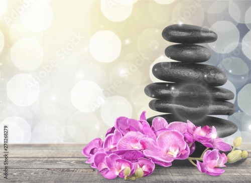 Zen basalt stones and flowers on white background