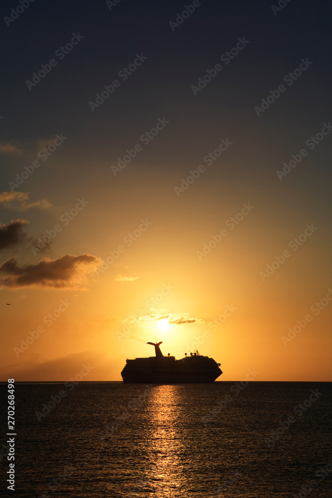 a cruise ship sails along the horizon at sunset a cruise ship sails along the horizon at sunset