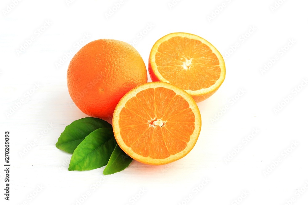 Orange fruit and one cut in half, with leaf isolated on white background.
