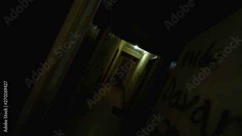 Old Apartment,Ghetto Building,long Dark Hallway.Tracking inside a dark long hallway of a ghetto apartment complex.Graffiti vandalism and abandonment in a poverty stricken neighbourhood.