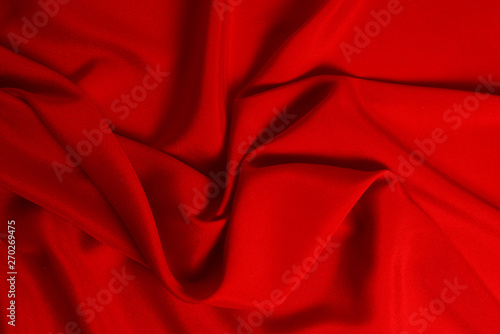 Red silk or satin luxury fabric texture can use as abstract background. Top view.