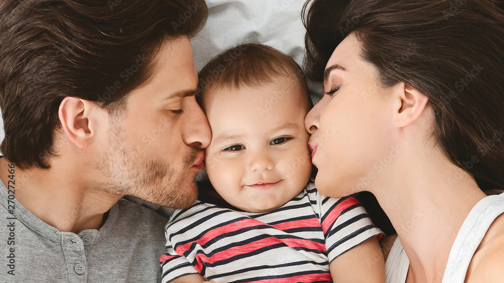 Parents kissing their cute beloved baby, panorama Parents kissing their cute beloved baby, panorama