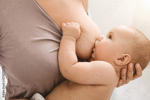 Fotografie, Obraz Mother breast feeding and hugging her baby